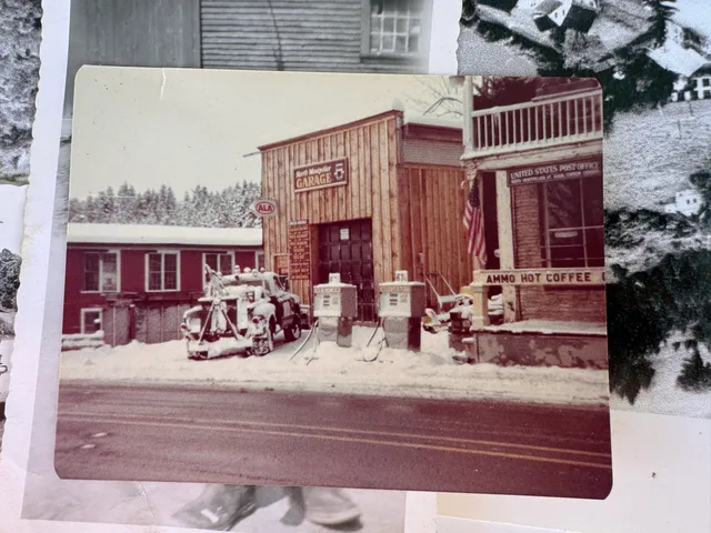 Winter photo of the North Montpelier Garage and United States Post Office buildings, snow-covered.