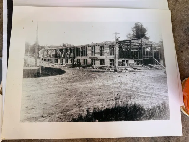 Mill building under construction, wooden frame exposed.