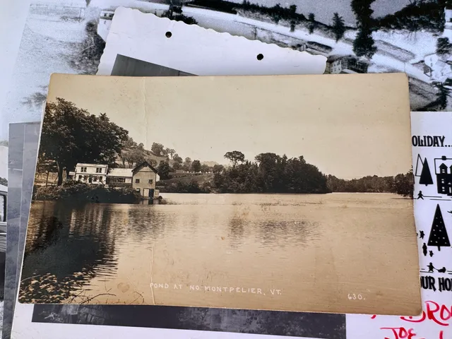 Sepia-toned postcard captioned "Pond at No. Montpelier, VT" showing the millpond and mill buildings.